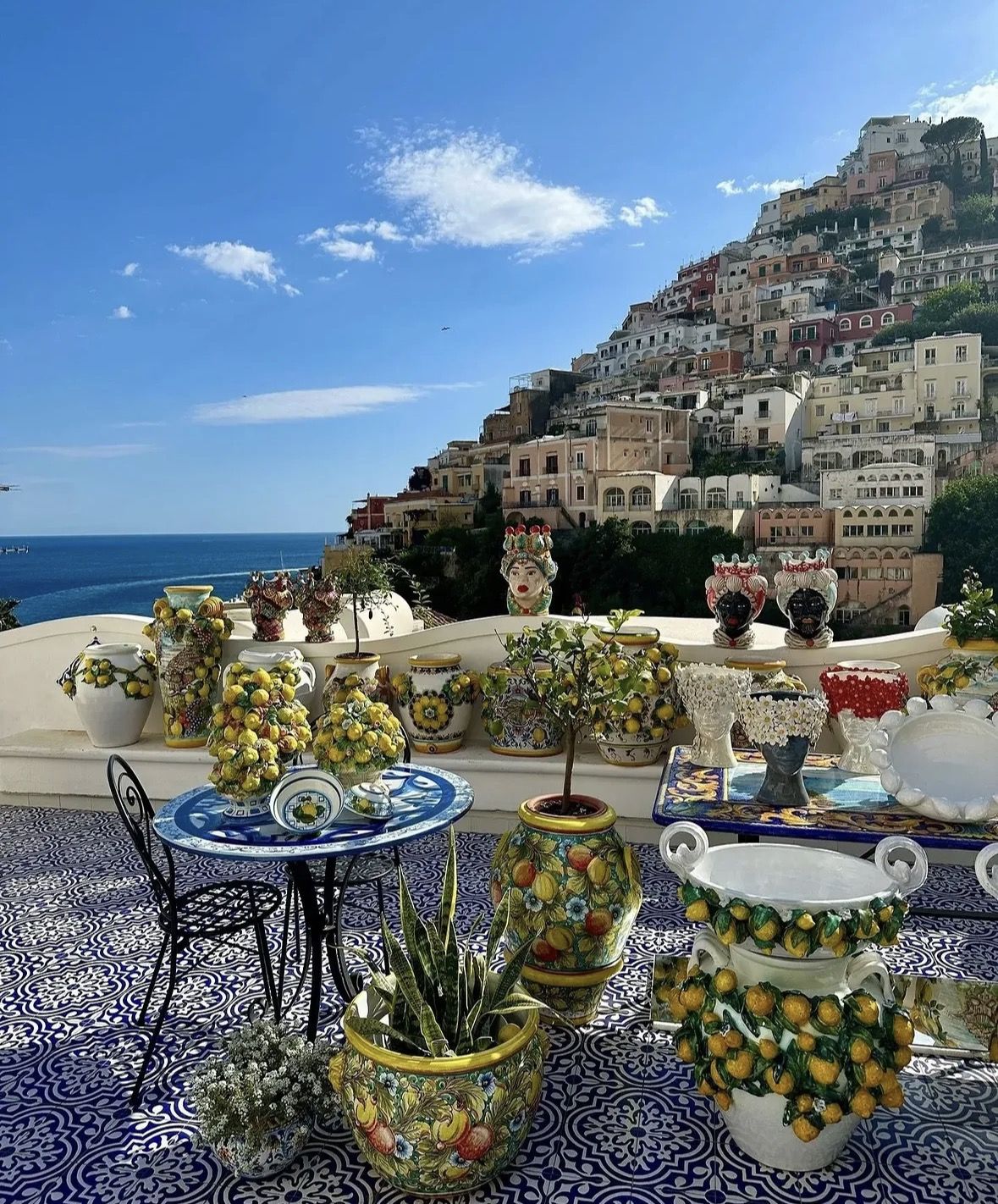 Local vendor selling limoncello and sfusato lemons at a colourful market stall in Amalfi town